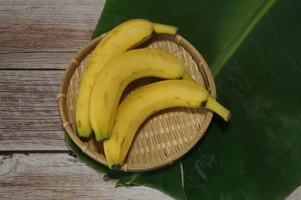 木の背景に葉を持つバナナの実 — ストック写真
