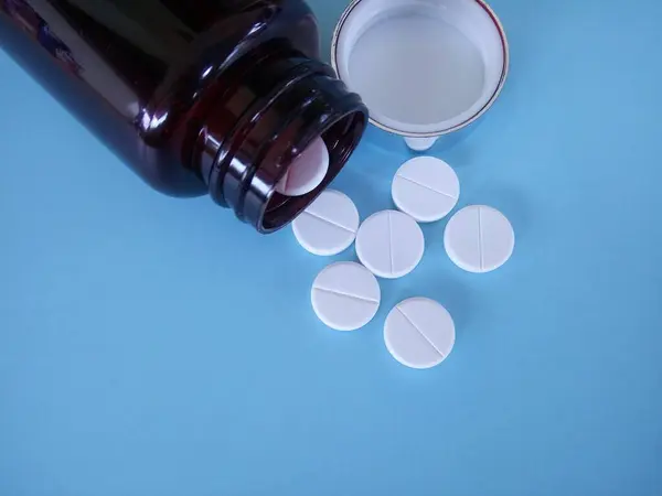 Pastillas Con Botella Sobre Fondo Azul —  Fotos de Stock