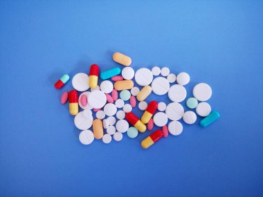 Mavi arka planda izole kapsüller ve haplar