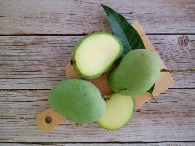 Ahşap arka planda yeşil mango meyveleri