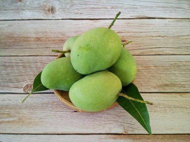 Ahşap arka planda yeşil mango meyveleri