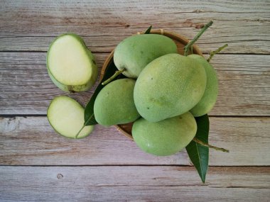 Ahşap arka planda yeşil mango meyveleri