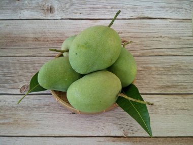 Ahşap arka planda yeşil mango meyveleri