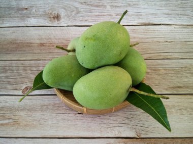 Ahşap arka planda yeşil mango meyveleri
