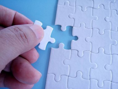 Mavi arka planda insan eli beyaz yapboz kağıdı