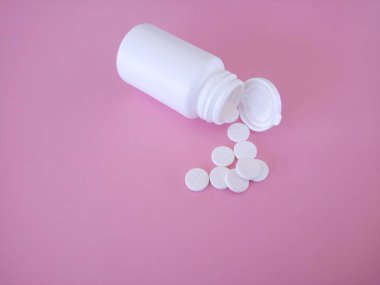 Pembe arka planda şişesi olan haplar