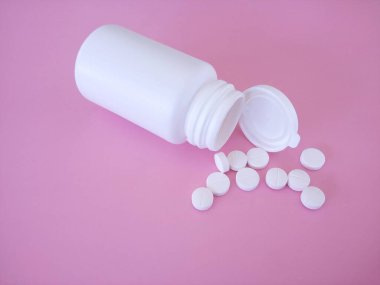 Pembe arka planda şişesi olan haplar