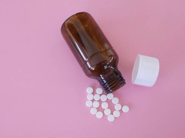 Pembe arka planda şişesi olan haplar