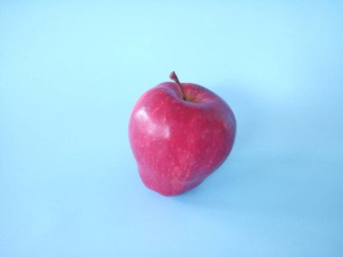 Kırmızı elma mavi arkaplanda izole edilmiş.