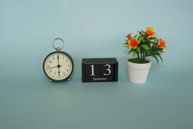 Mavi arka planda çiçek ve küp tarihi olan çalar saat. Ocak ayı konsepti.