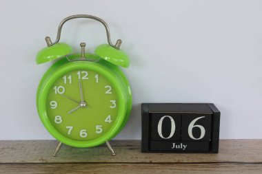 yeşil alarm saati ve küp takvim tarihi 6 Temmuz 'da masada