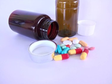 Beyaz arka planda şişesi olan haplar veya kapsüller