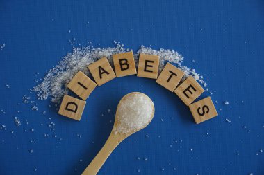 Beyaz şeker ve mavi arka planda kaşık. Diyabet kavramı