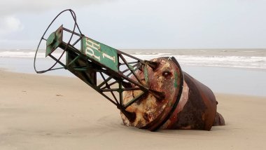 Kumsalda eski paslı balıkçı tekeri
