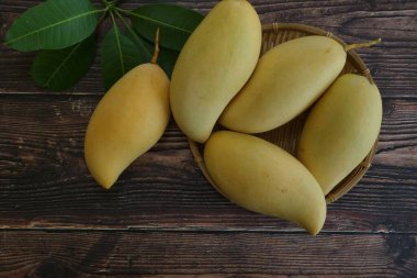 Ahşap arka planda sarı mango