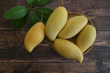 Ahşap arka planda sarı mango