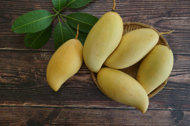 Ahşap arka planda sarı mango