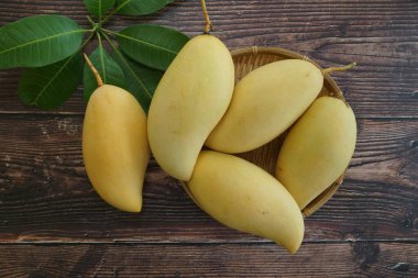 Ahşap arka planda sarı mango