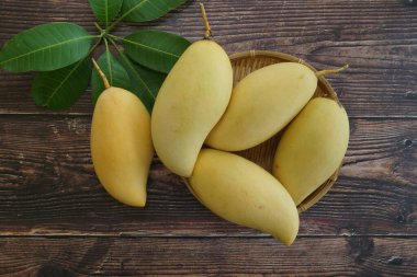 Ahşap arka planda sarı mango