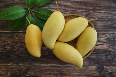 Ahşap arka planda sarı mango