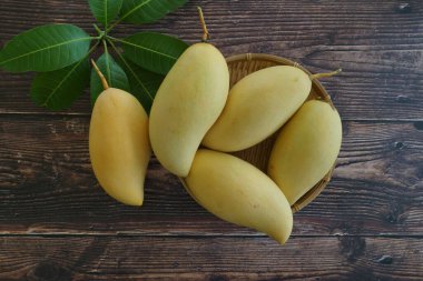 Ahşap arka planda sarı mango