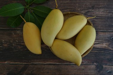 Ahşap arka planda sarı mango