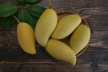 Ahşap arka planda sarı mango