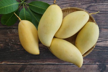 Ahşap arka planda sarı mango