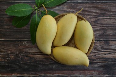 Ahşap arka planda sarı mango