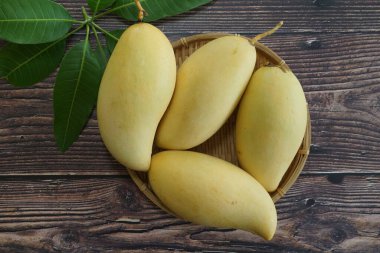 Ahşap arka planda sarı mango