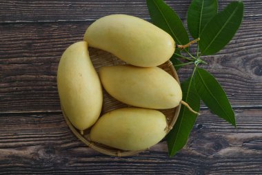 Ahşap arka planda sarı mango