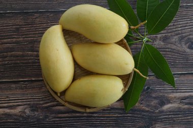 Ahşap arka planda sarı mango