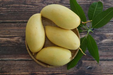 Ahşap arka planda sarı mango