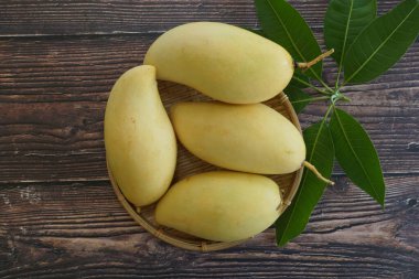 Ahşap arka planda sarı mango