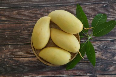 Ahşap arka planda sarı mango