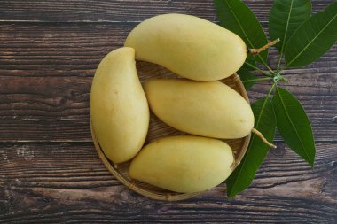 Ahşap arka planda sarı mango