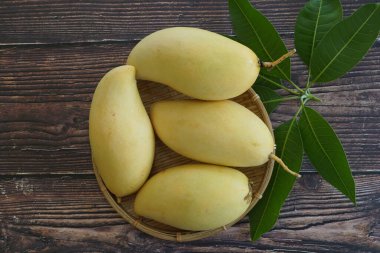 Ahşap arka planda sarı mango