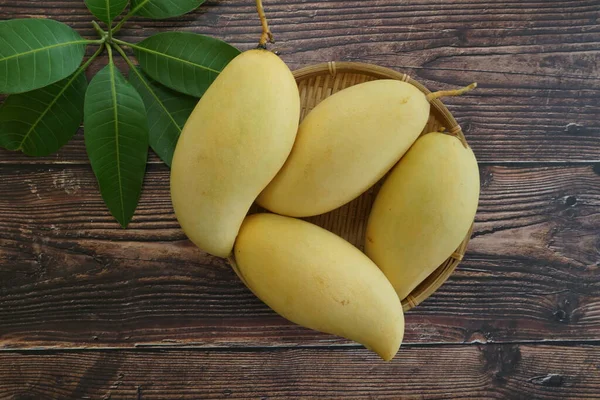 Ahşap arka planda sarı mango