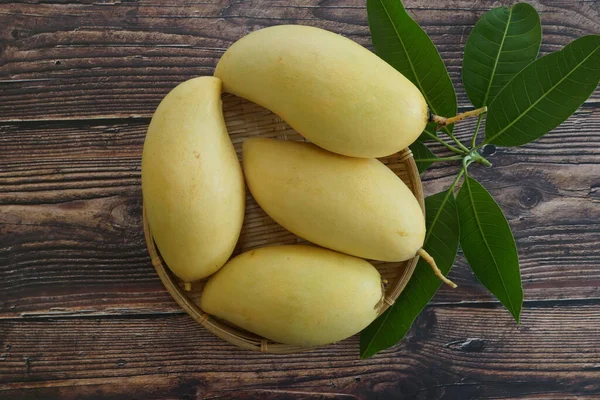 Ahşap arka planda sarı mango