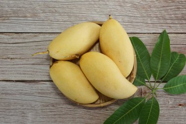 Ahşap arka planda sarı mango