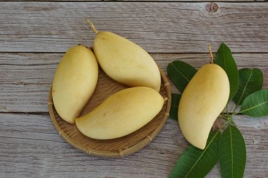 Ahşap arka planda sarı mango