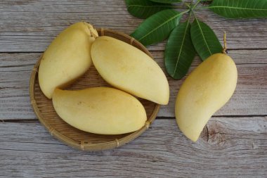 Ahşap arka planda sarı mango
