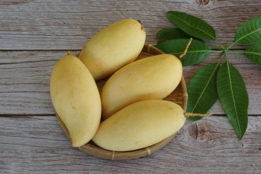 Ahşap arka planda sarı mango