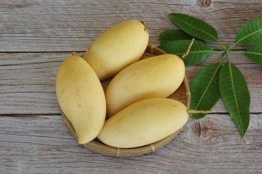 Ahşap arka planda sarı mango