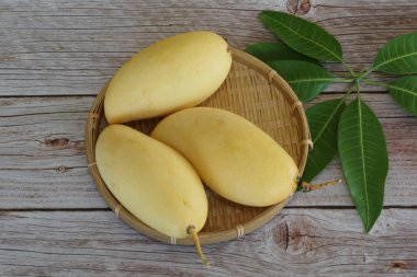 Ahşap arka planda sarı mango