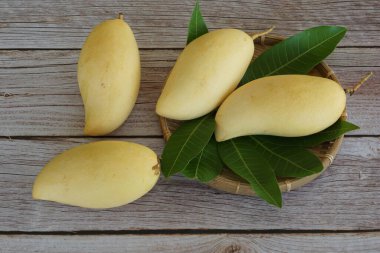 Ahşap arka planda sarı mango