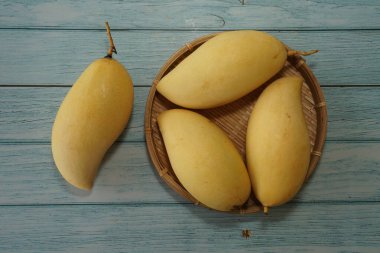 Ahşap arka planda sarı mango