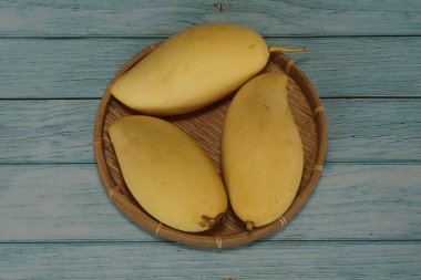 Ahşap arka planda sarı mango