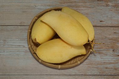 Ahşap arka planda sarı mango
