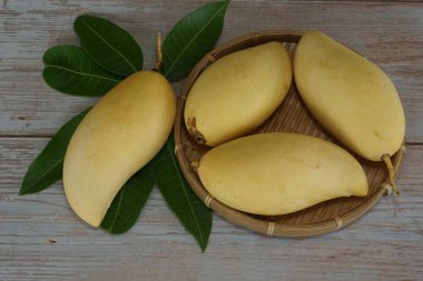 Ahşap arka planda sarı mango